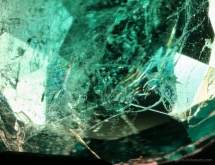 Orange and bluish flash effect in natural Colombian emerald treated with artificial resin fracture filling