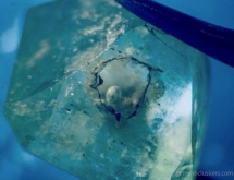 Artificial resin with gas bubble filling very large cavity in natural emerald